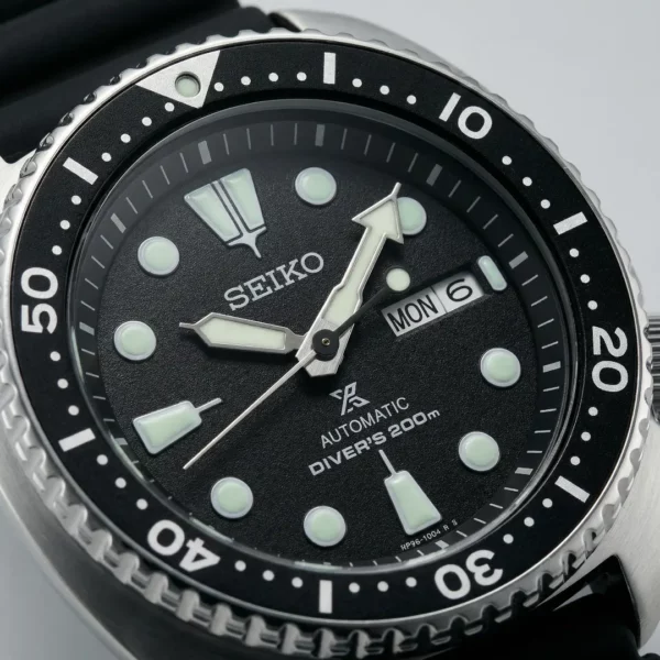 seiko-prospex-turtle-macro Détail du cadran d’une montre de plongée avec index et aiguilles luminescents